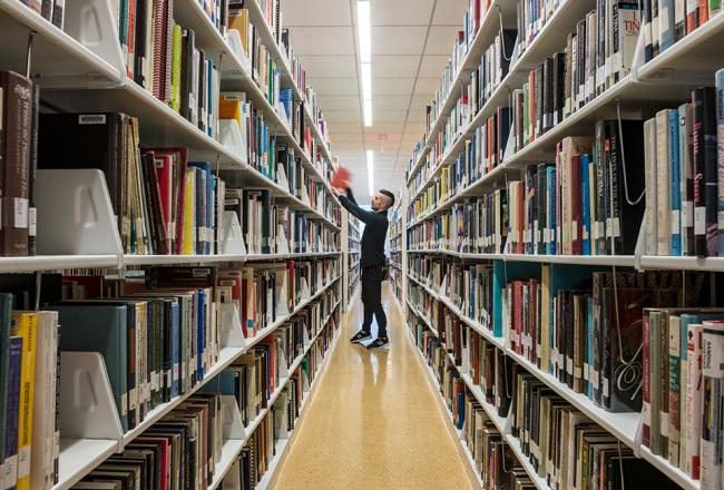 Student in the stacks in the library