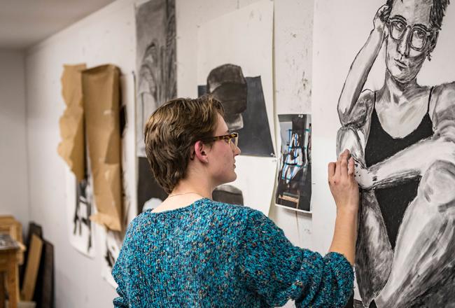 Student working on a self portrait in art class