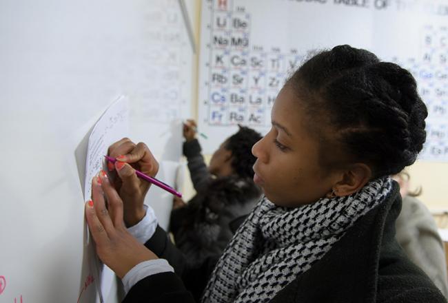 Student writing on a whiteboard