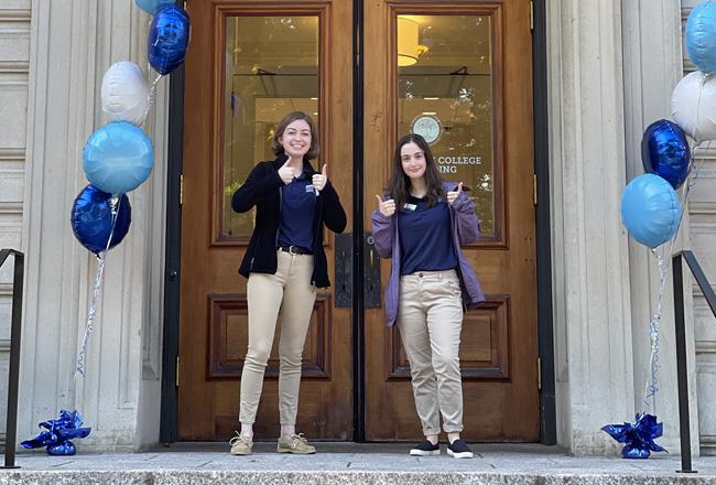 Two Simmons students welcoming people to an open house on the MCB front steps