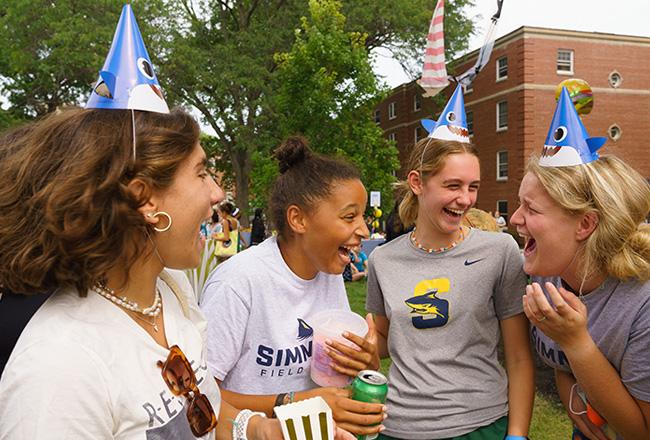 students laughing in shark hats on res quad