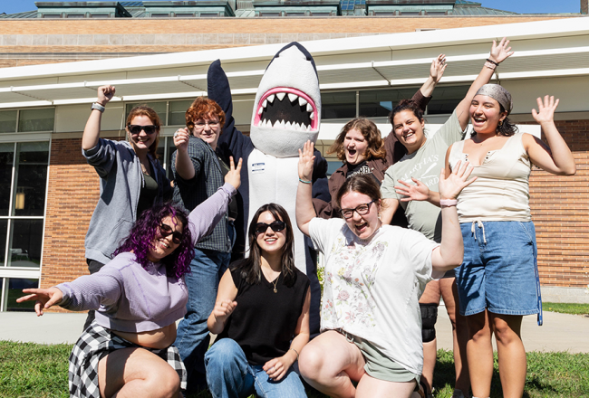 A group of orientation leaders and Stormy waving with excitement 