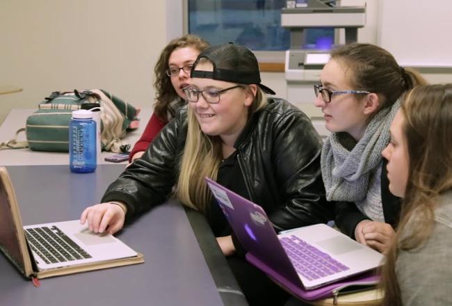 Students working together around laptops