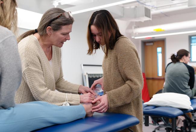 Student and Faculty examining ankle of volunteer patient