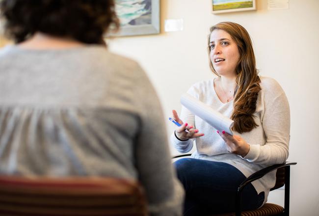 Two Simmons social work students seated across from each other and engaged in conversation