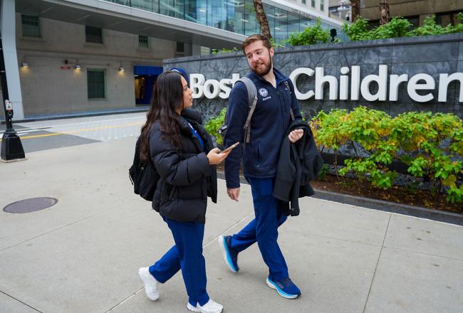 2 Simmons nursing students talking as they walk past the Boston Children's Hospital