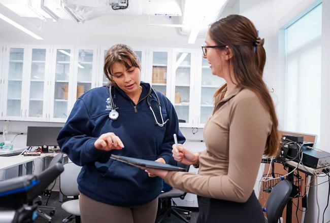 Two Simmons Physical Therapy students working in a lap and sharing a tablet