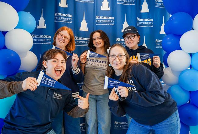 Studens posing at selfie station with Simmons swag