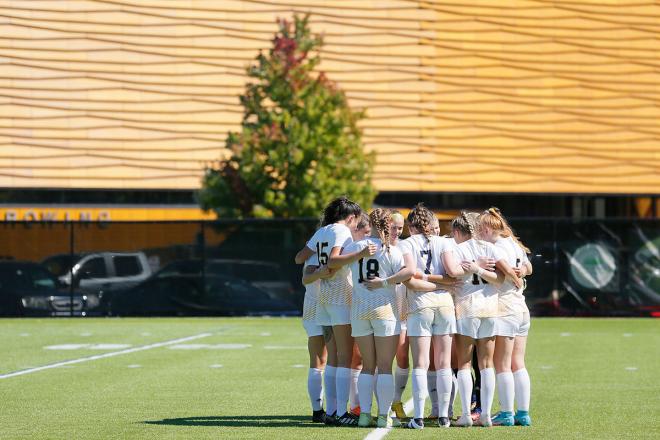 The Simmons soccer team in a huddle. Photograph by Mike Broglio.