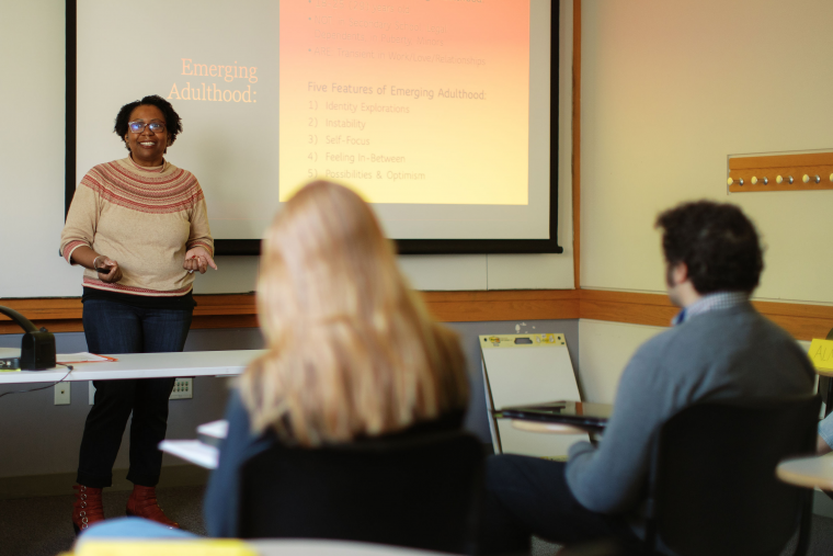 A graduate faculty member talks to a classroom of students at Simmons