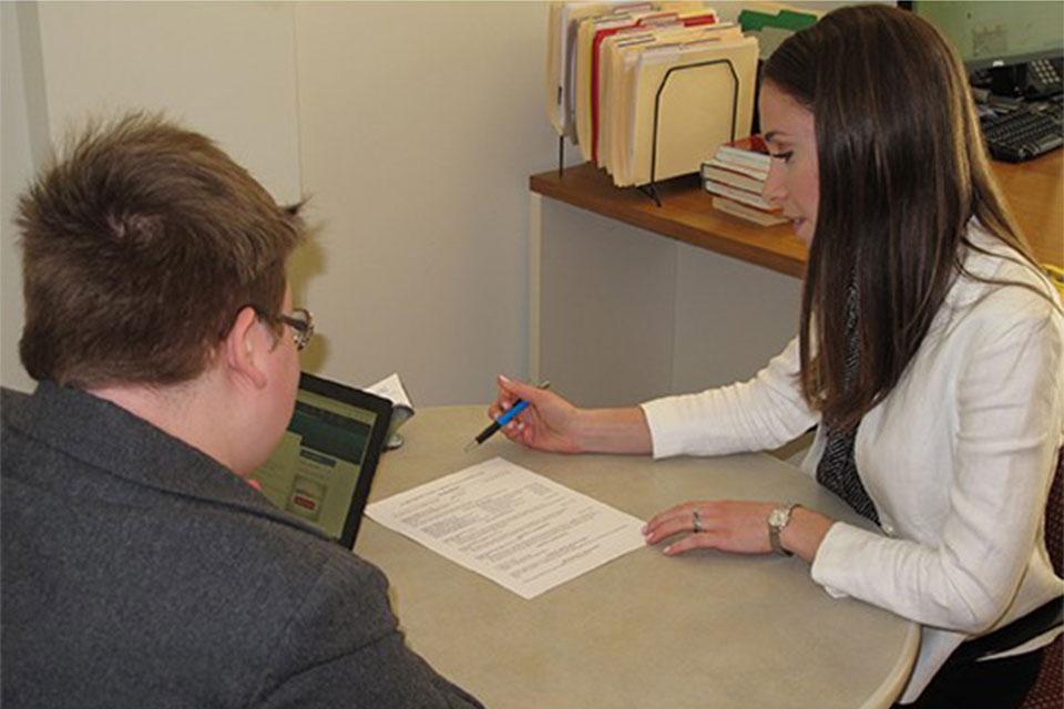 Career Education Center staff member reviewing a students resume in an office.