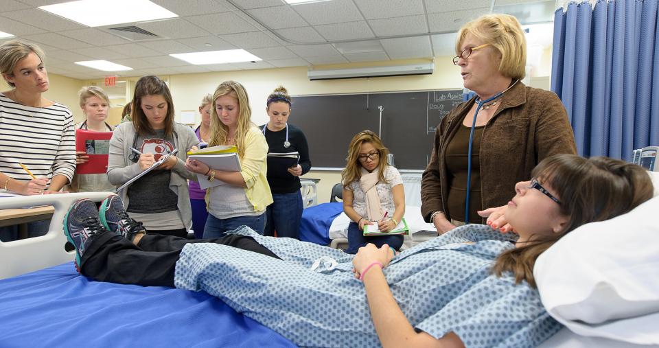 Nursing students examining a mock patient