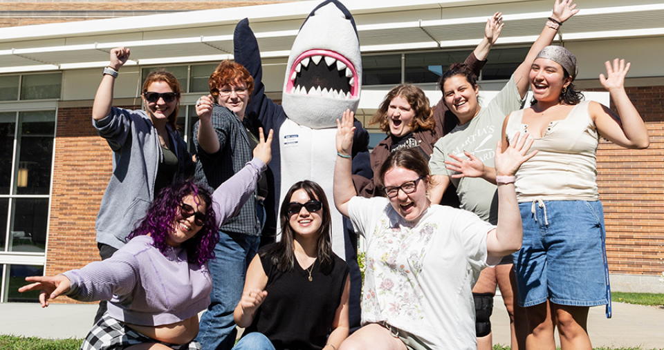 A group of orientation leaders and Stormy waving with excitement 
