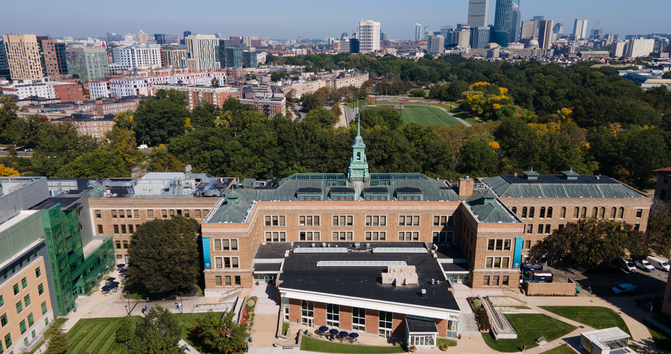 An aerial photo of the Main College Building on the Simmons campus, with the city of Boston in the background