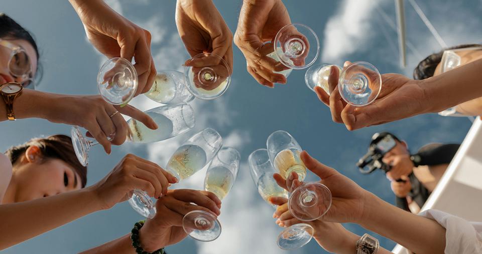 A group of people in a circle toasting with glasses of champagne