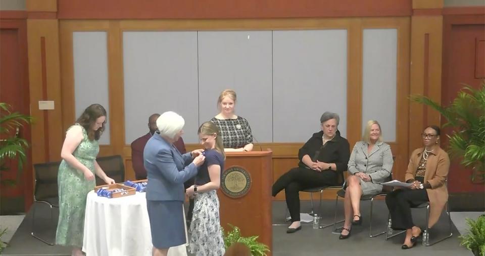 A graduating student in the Nursing program receives her Nursing pin
