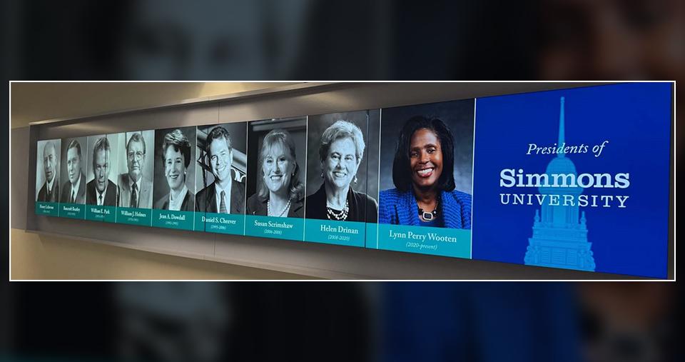 A hallway sign displaying all of the Presidents of Simmons University