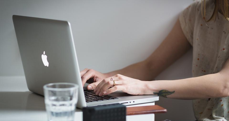 Hands typing on laptop