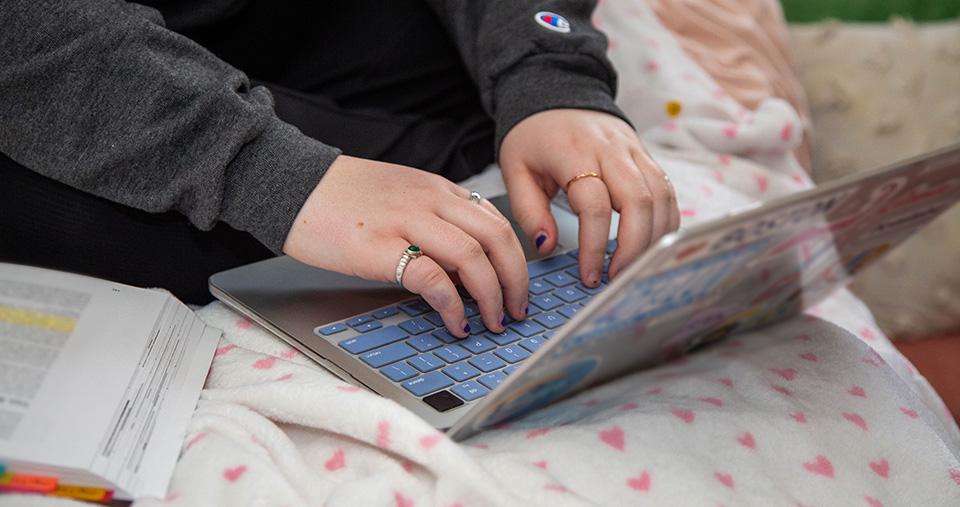 Hands typing on laptop