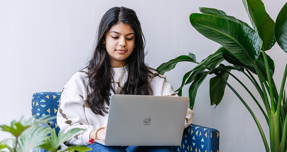Student using laptop in chair