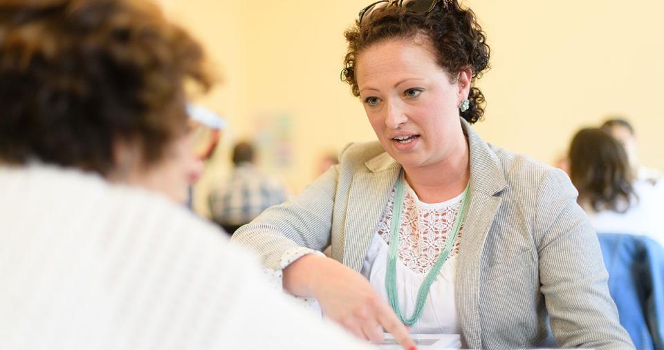 Two adult Simmons students having a conversation during a class