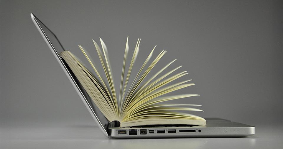 Paperback book opened on a laptop