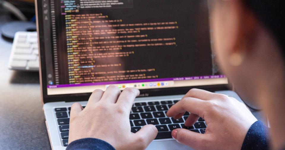 A computer science student using their laptop to write code