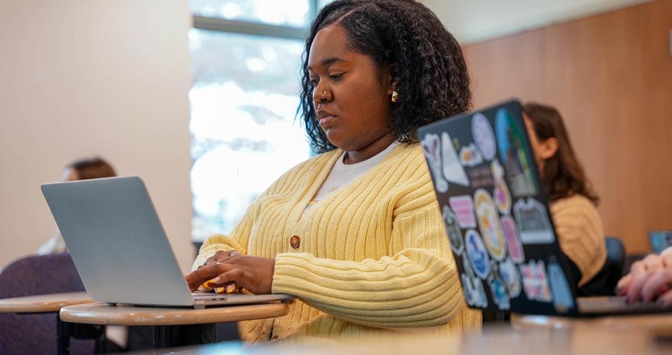 Social Work graduate student on laptop.