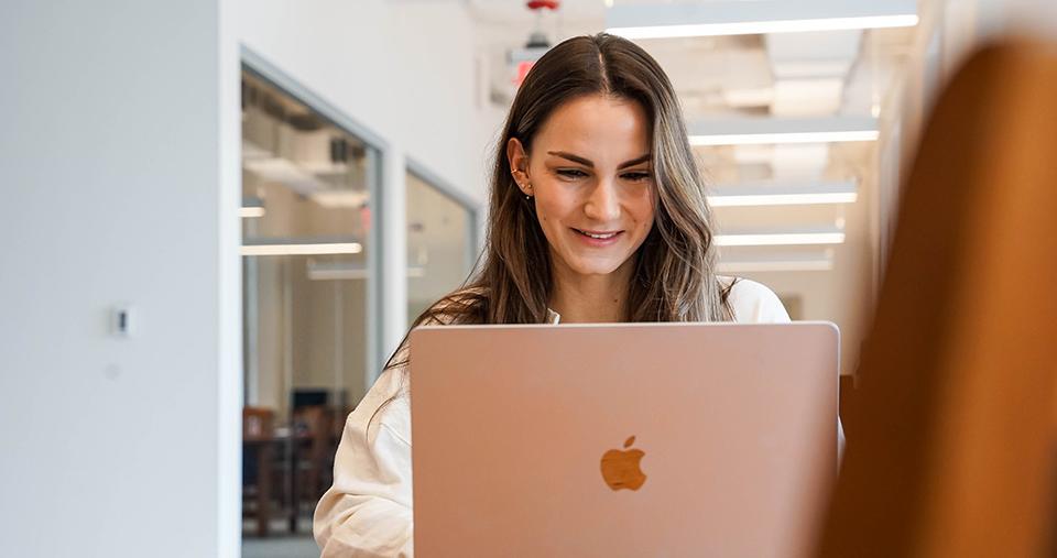 Student working in library on macbook