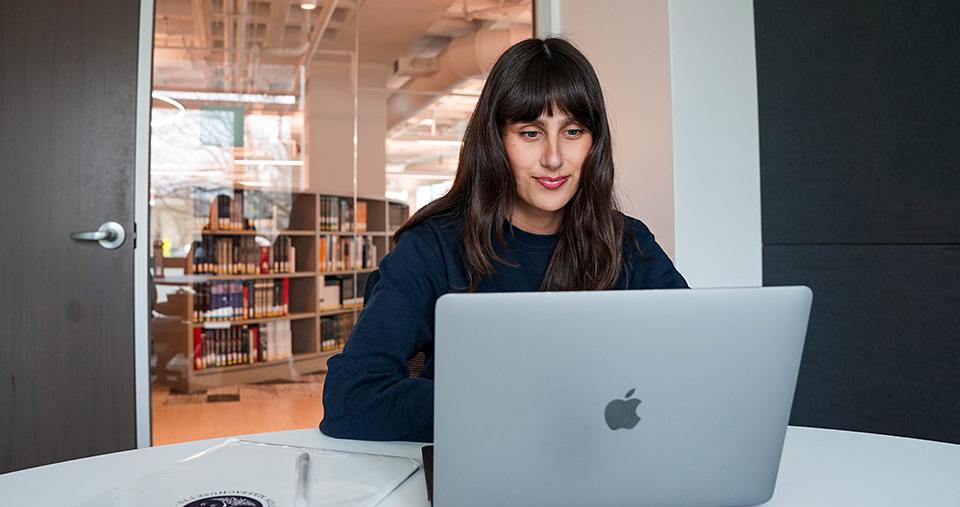Student working in study room of library on laptop