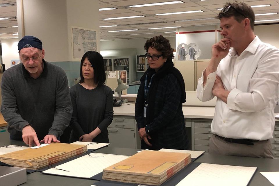 Conservators Alan Haley, Qui Qi, Ann Roddy, and Dan Patterson in the conservation department of the Library of Congress, working with the Yongle Da Dian.