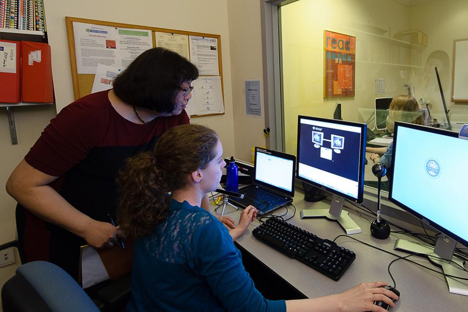 Professor and student working on a computer