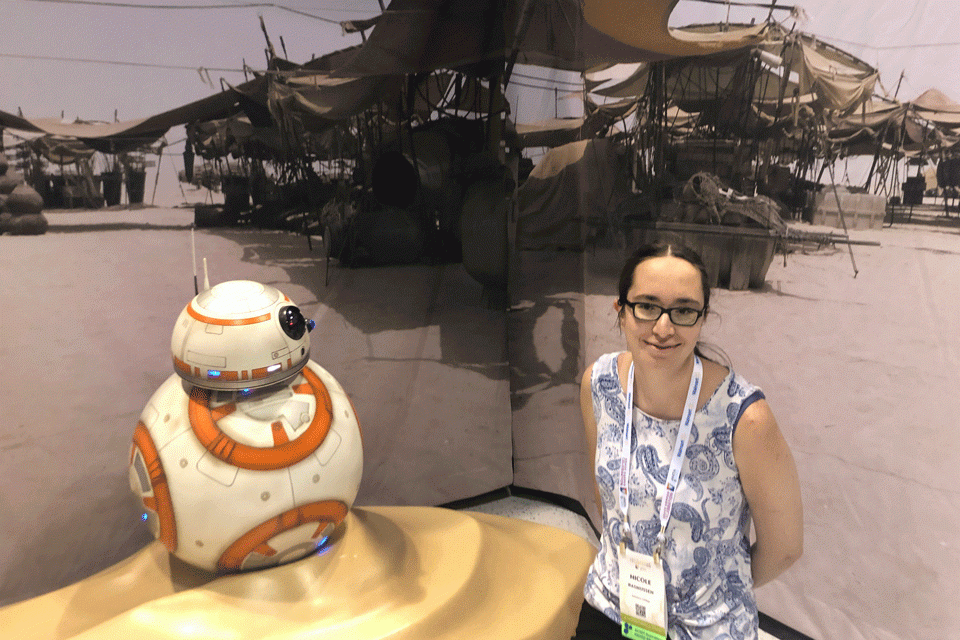 Nicole Rasmussen standing with a model of Star Wars' BB-8 at the Grace Hopper Celebration, Fall 2019.