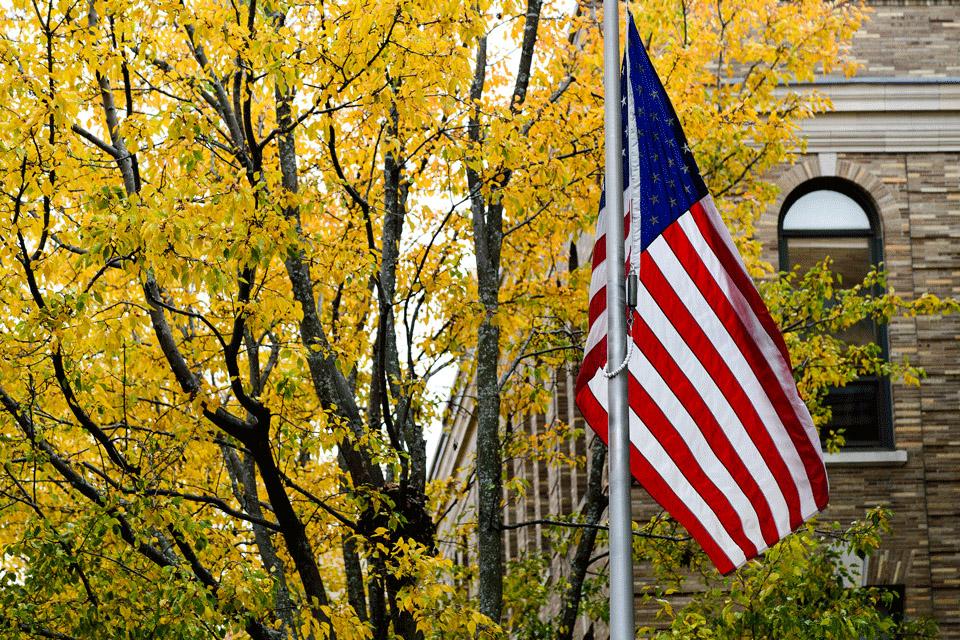 American Flag outside Simmons University in the Fall