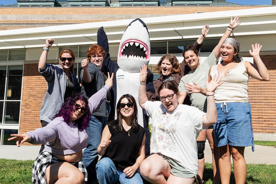 A group of orientation leaders and Stormy waving with excitement