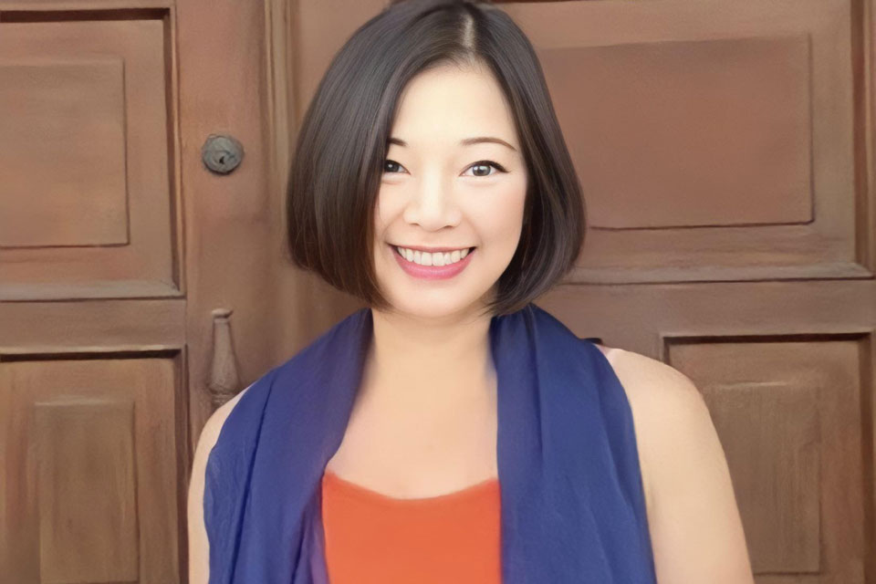 Marivi Soliven ’95 standing in front of a paneled wall and smiling